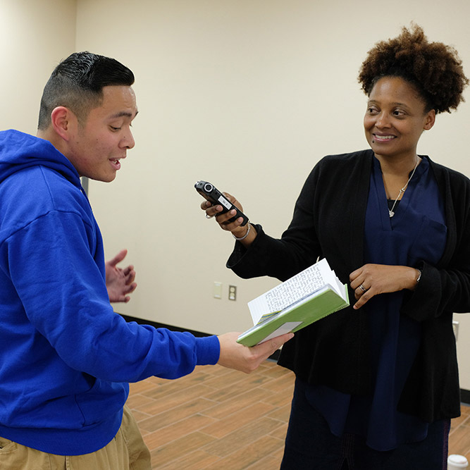 Airman Francis Willy reads some of his poetry with Poet Laureate Tracy K. Smith during Smith's visit to Cannon Air Force Base near Clovis, New Mexico. January 11, 2018. Credit: Shawn Miller.